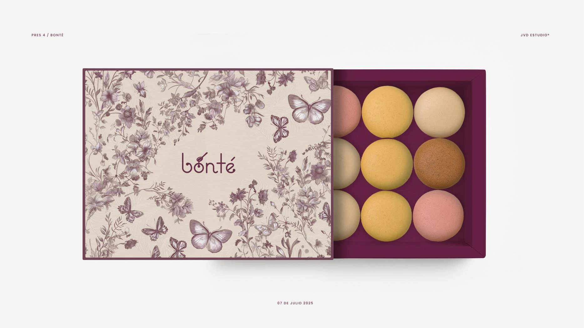 Caja de macarons abierta con interior burdeos.
