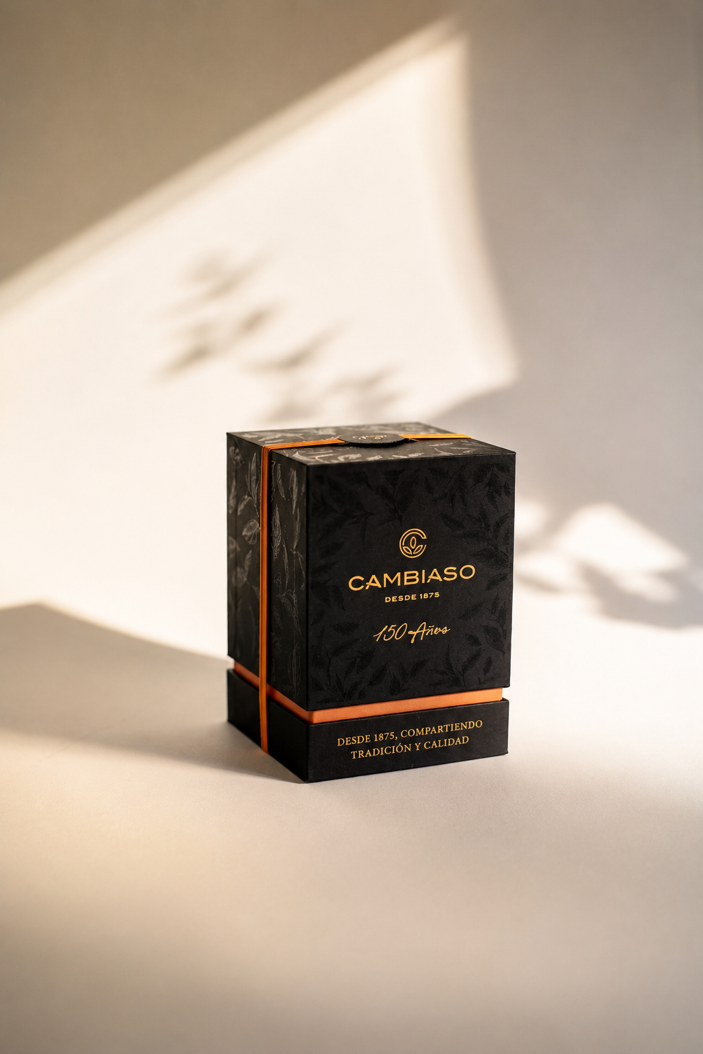 Closed case of the Cambiaso 150 años commemorative edition in black, gold and orange.