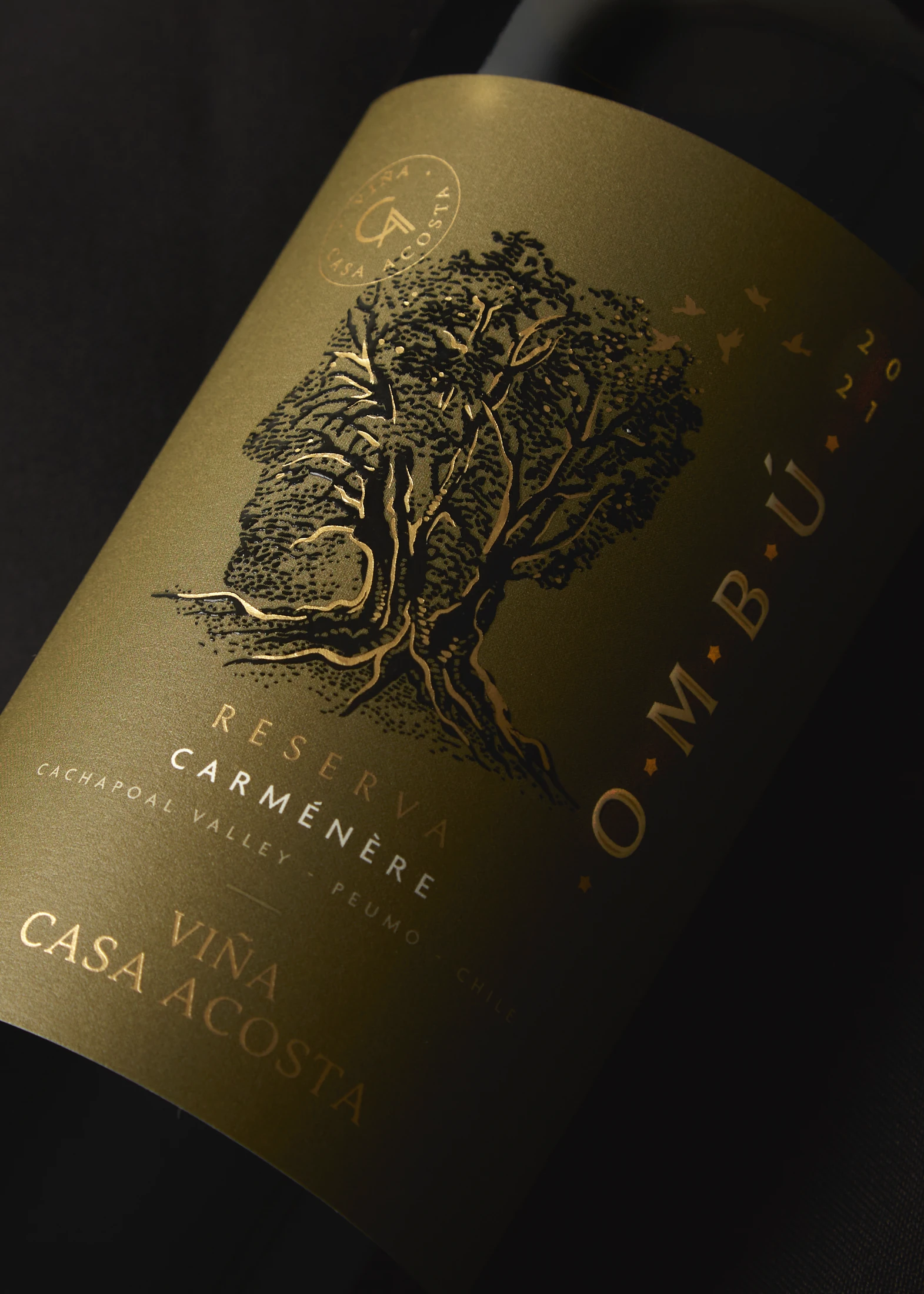 Detalle de la etiqueta Ombú Reserva Carménère: el grabado del ombú y la tipografía en dorado sobre papel oliva.