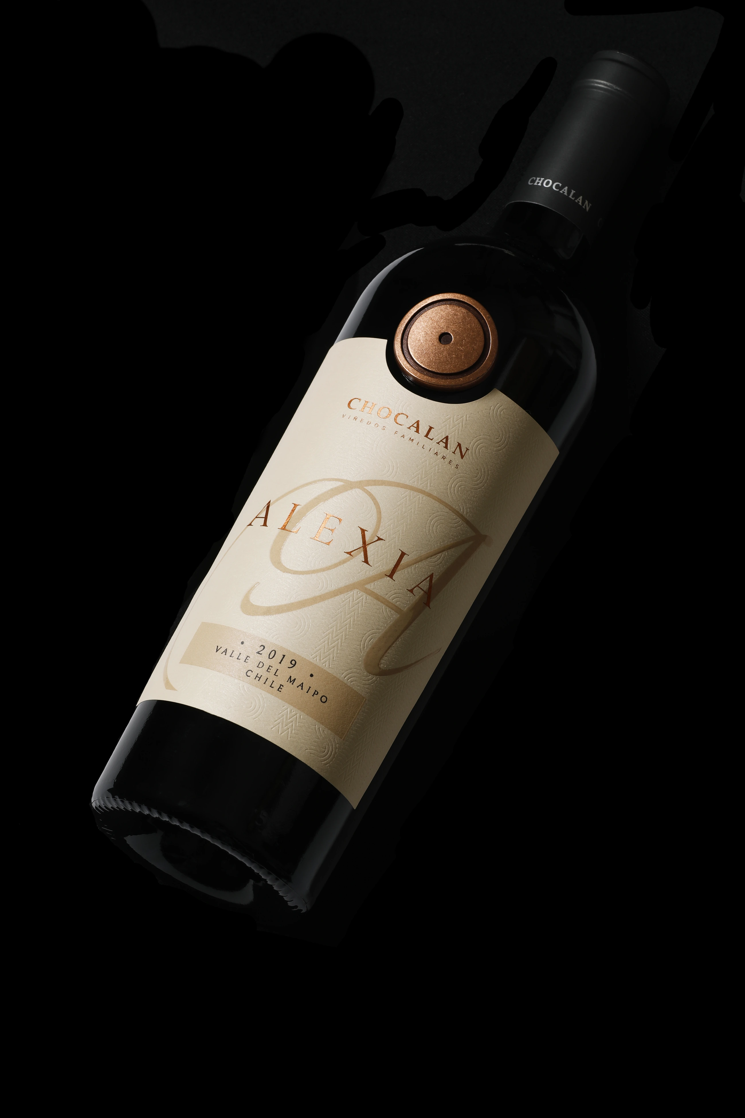 Botella Alexia de Viña Chocalán con etiqueta crema, monograma A y sello cobrizo.