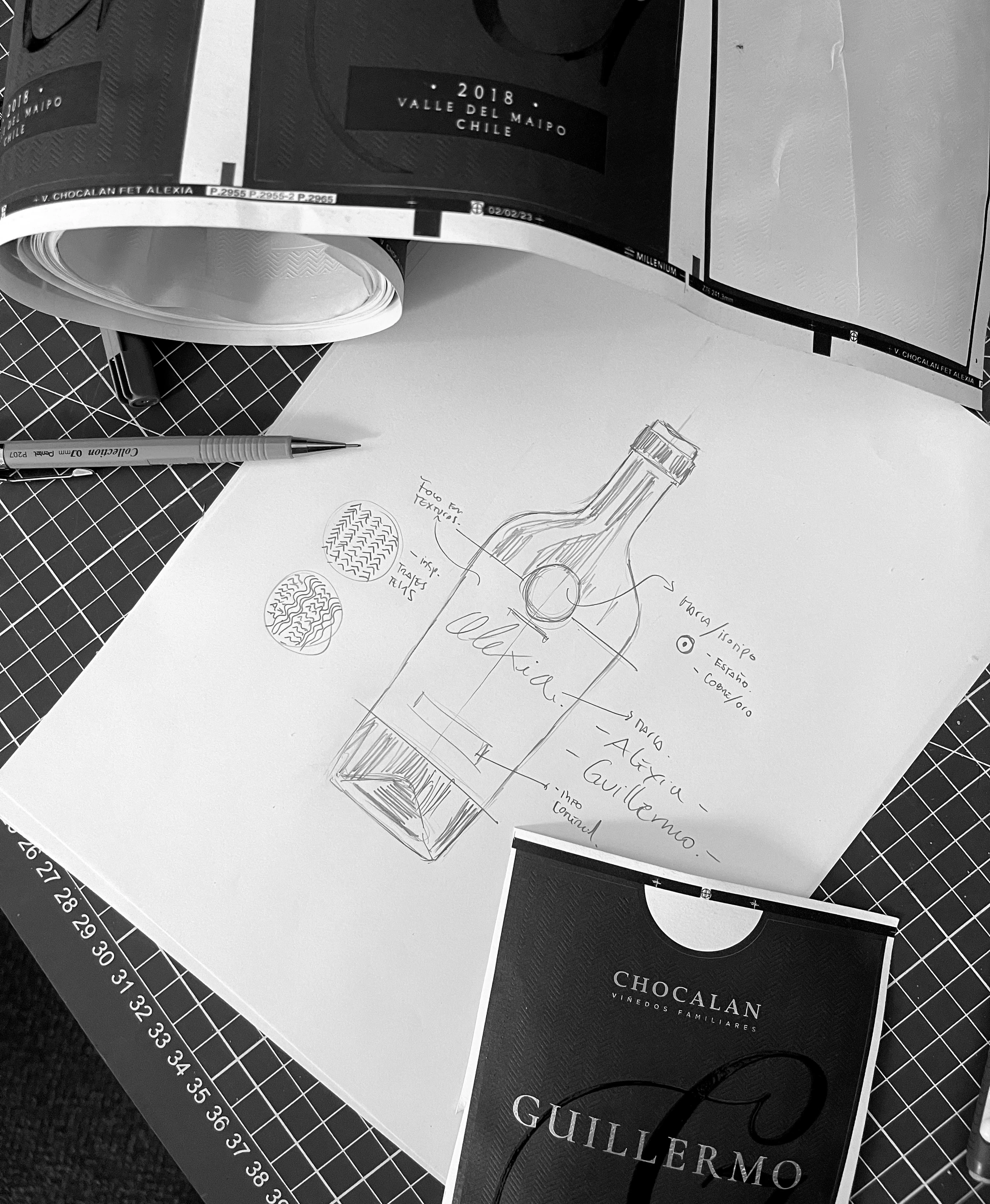 Boceto manual de la botella y etiquetas Alexia y Guillermo junto a pruebas impresas.