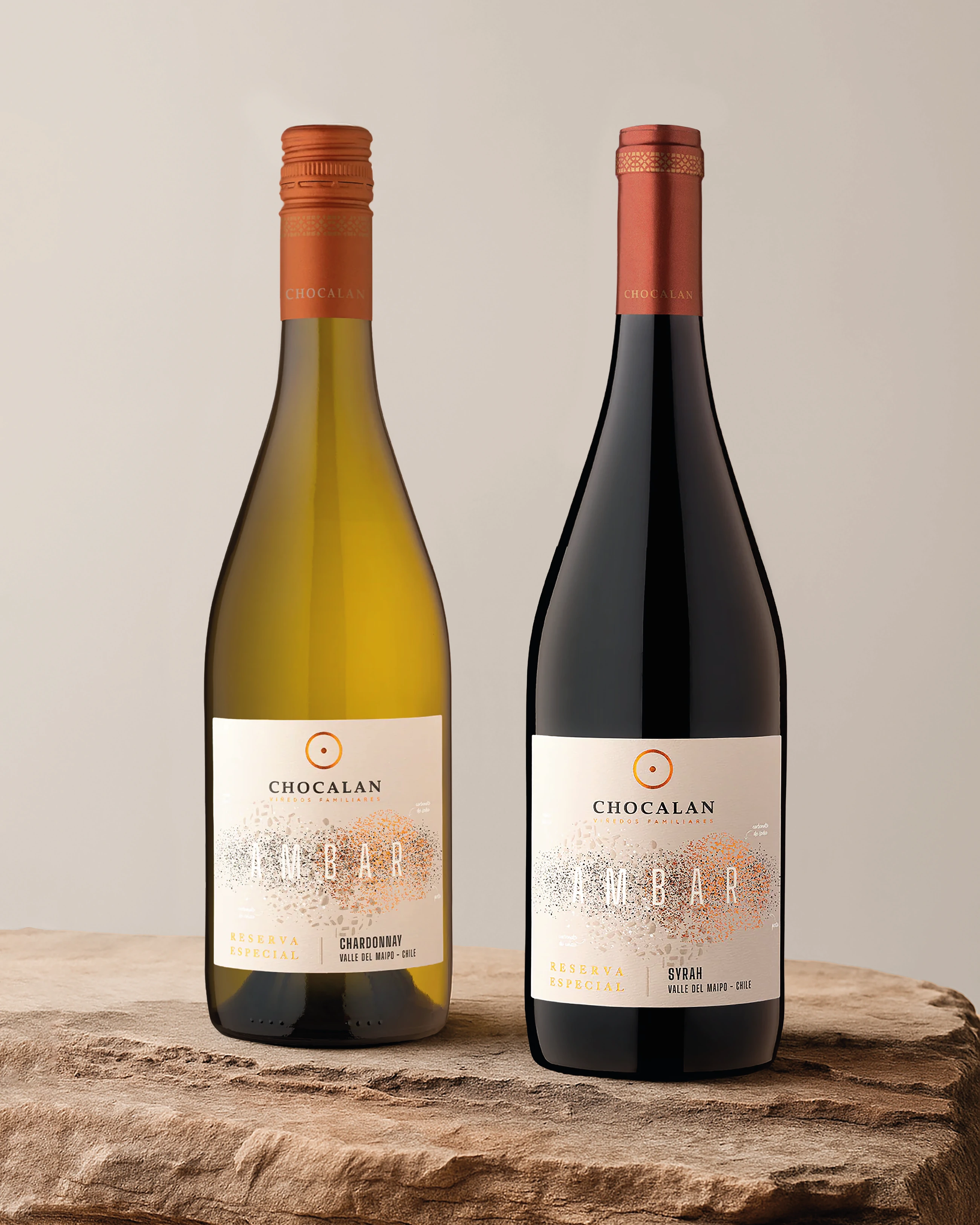 Botellas Ámbar blanca y tinta de Viña Chocalán sobre una base de piedra.