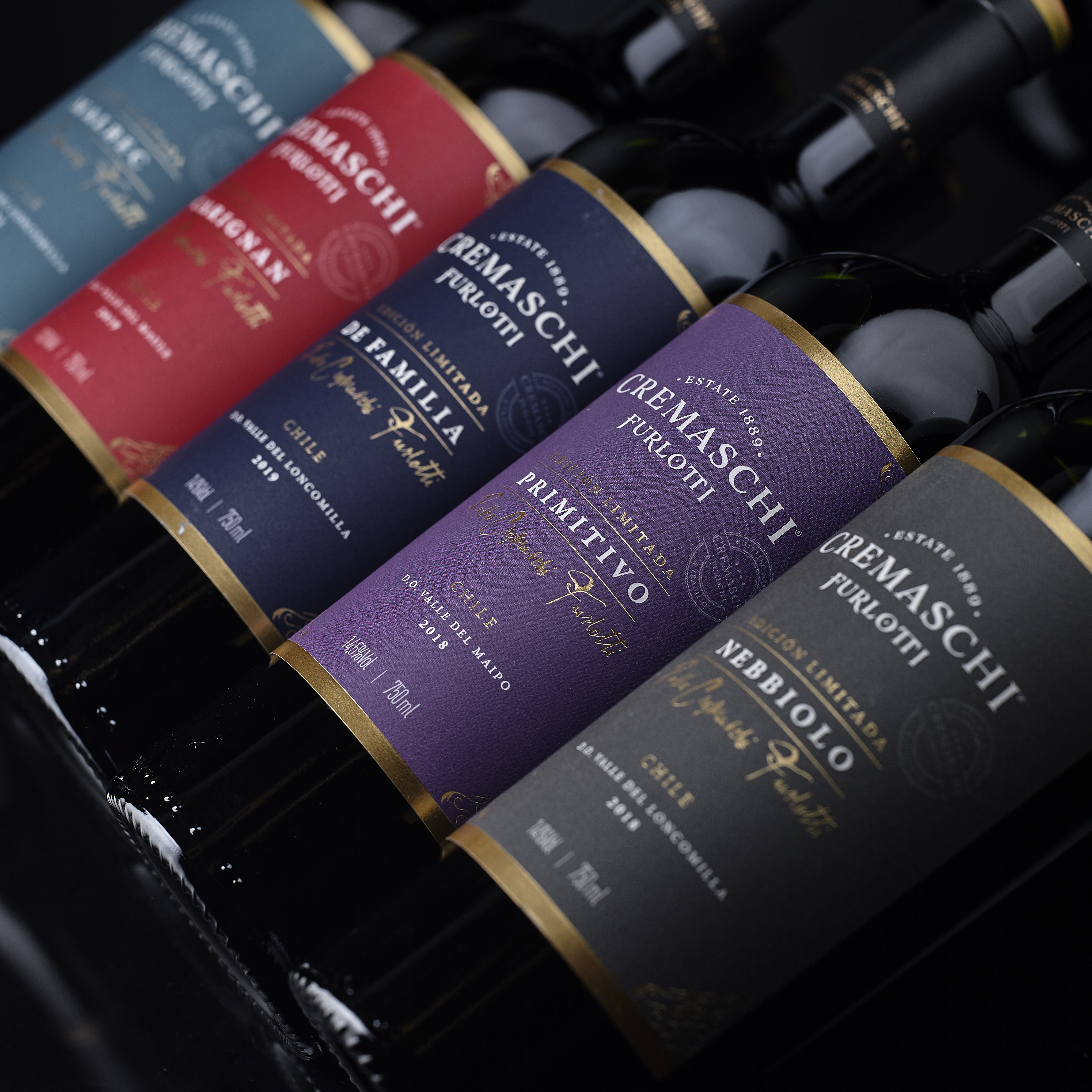 Familia de botellas Cremaschi Furlotti Edición Limitada en distintos colores, dispuestas en diagonal.