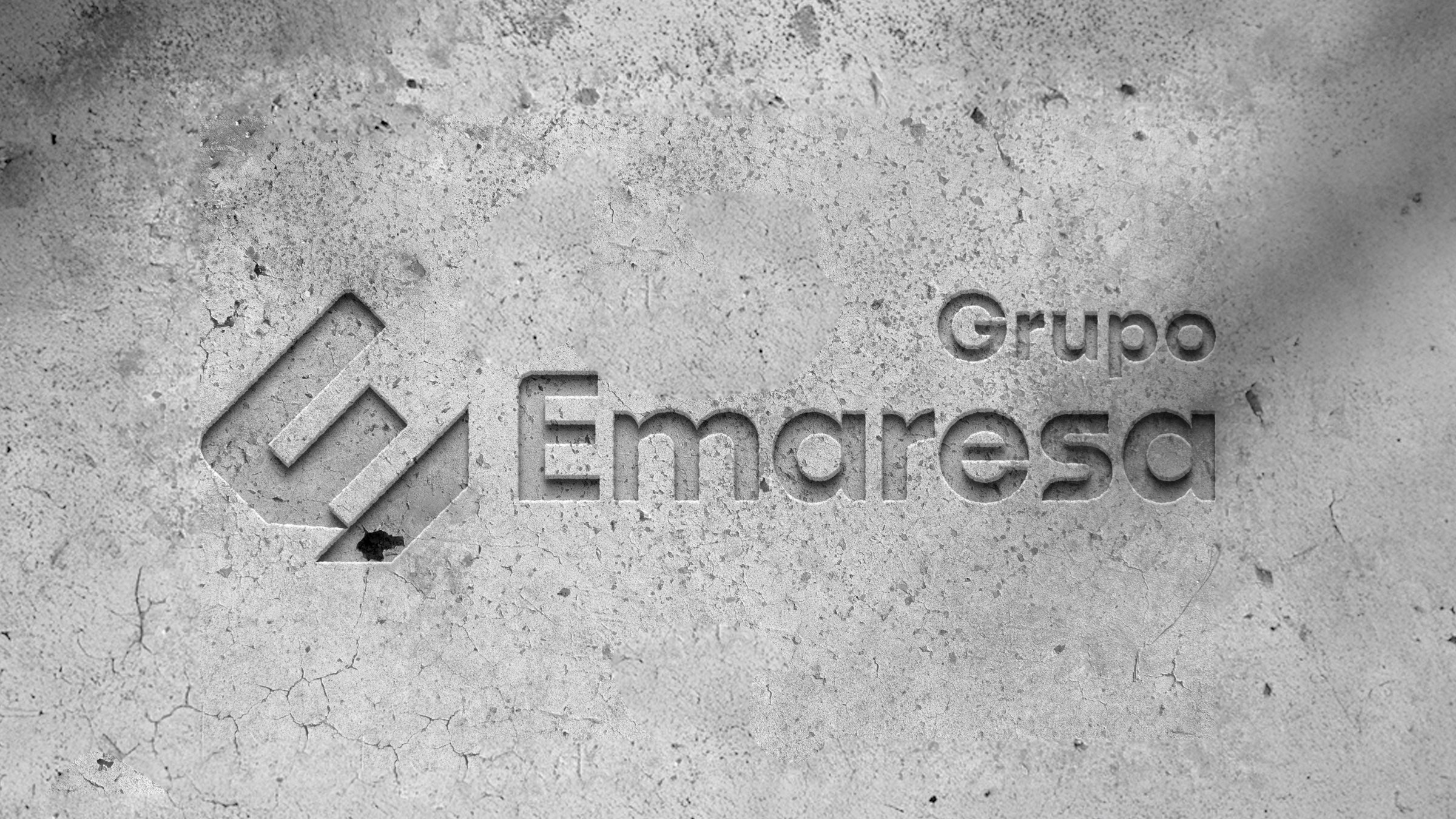 Grupo Emaresa's logotype embossed on a grey concrete surface