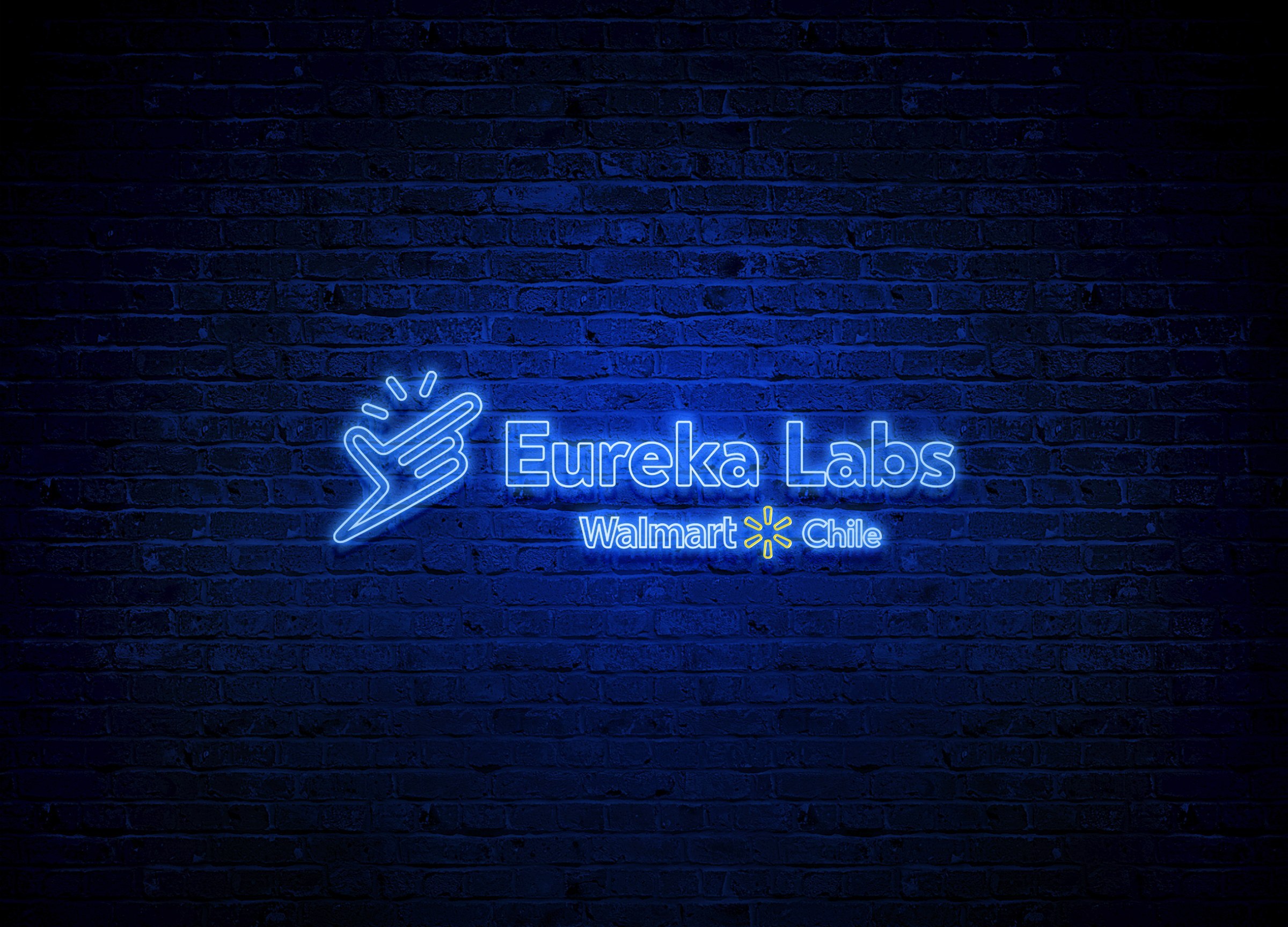 Logotipo luminoso azul de Eureka Labs aplicado sobre un muro oscuro