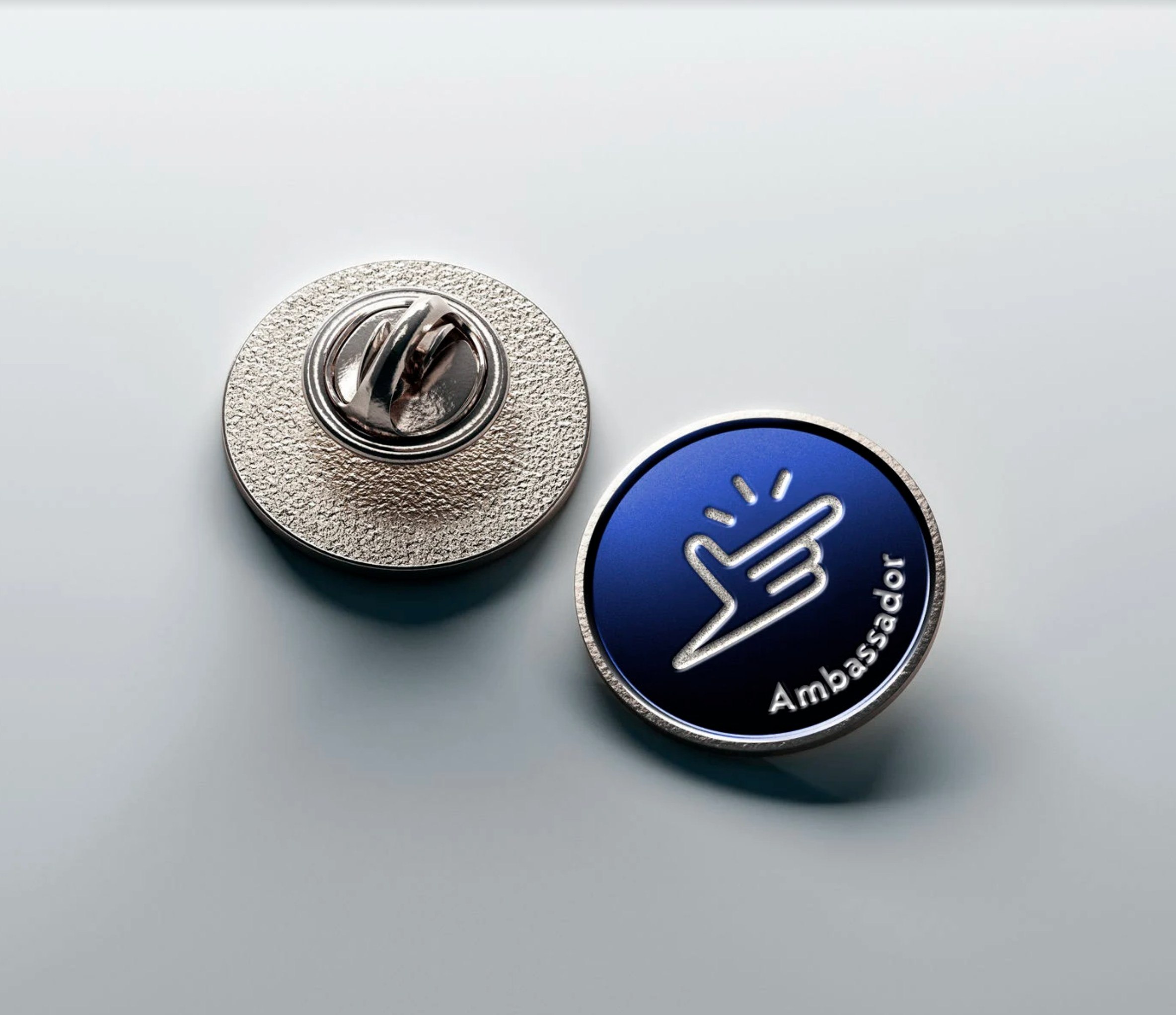 Pin metálico circular de Eureka Labs con isotipo azul sobre fondo oscuro