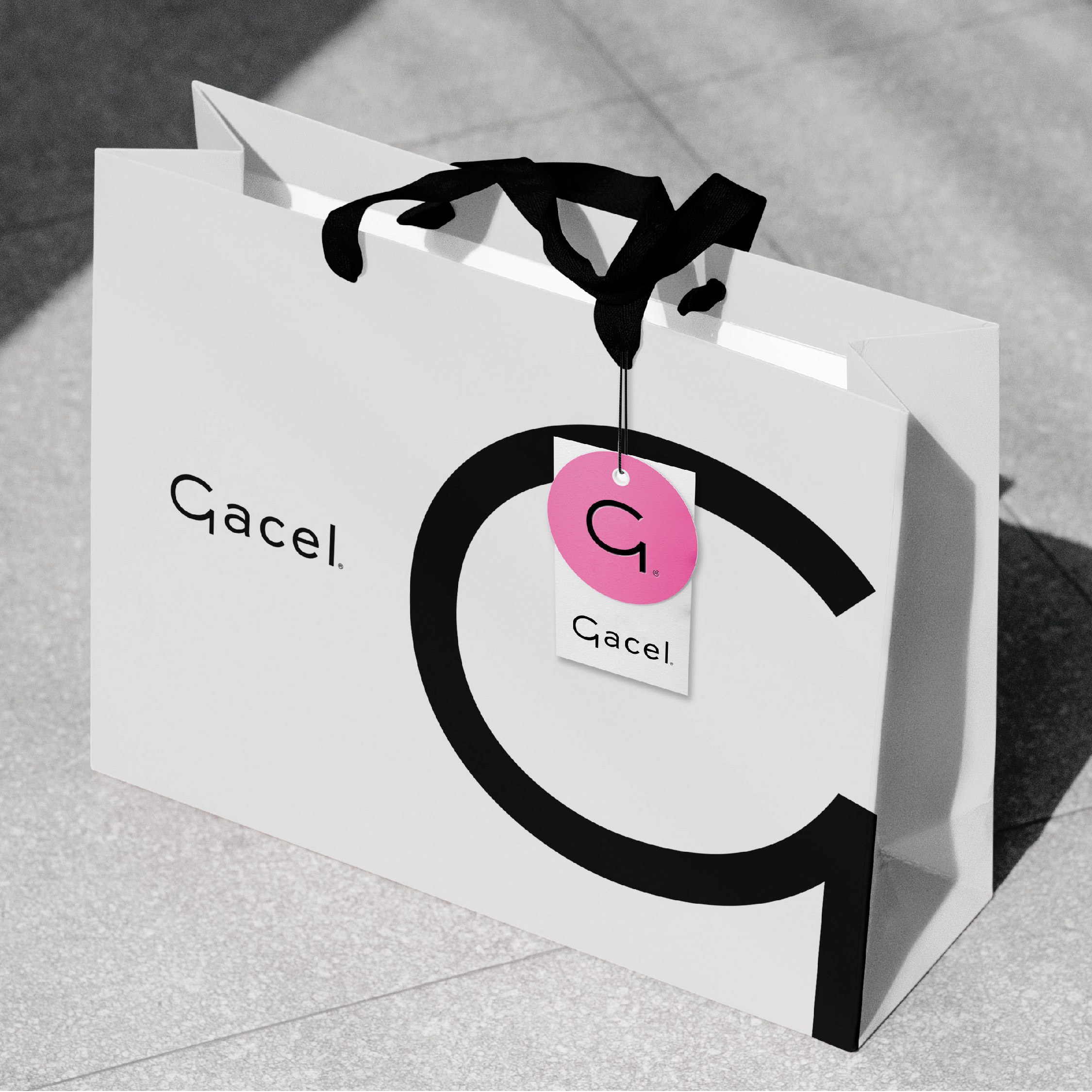 Gacel gift bag in black and white with the G isotype and a pink hang tag.