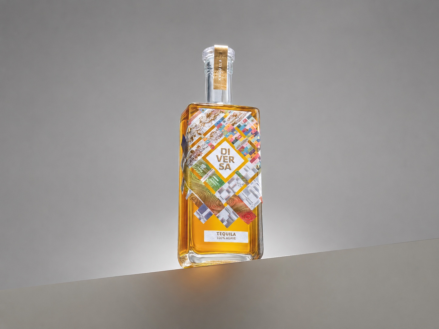 Botella DIVERSA Tequila con etiqueta de collage material construida por cinco estudios latinoamericanos, sobre fondo extendido