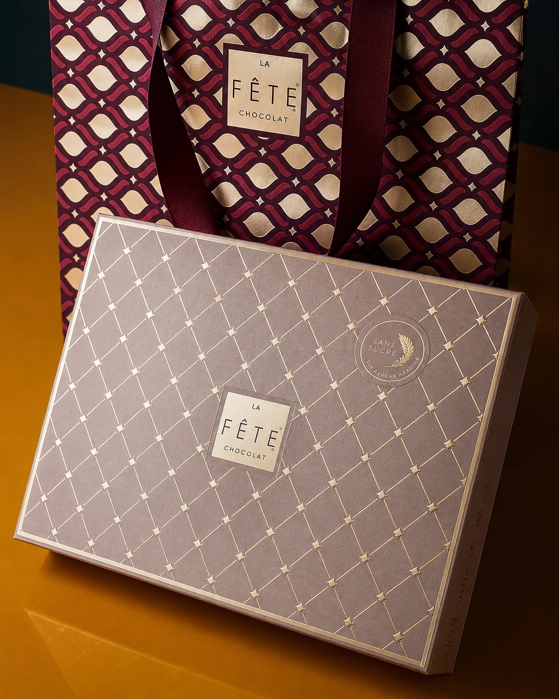 Caja La Fête Sans Sucre junto a una bolsa de regalo con el patrón gráfico de la marca