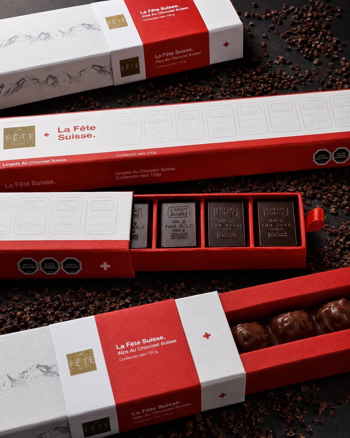 Estuche La Fête Suisse abierto con cuatro lingotes de chocolate al estilo de barras de oro fino
