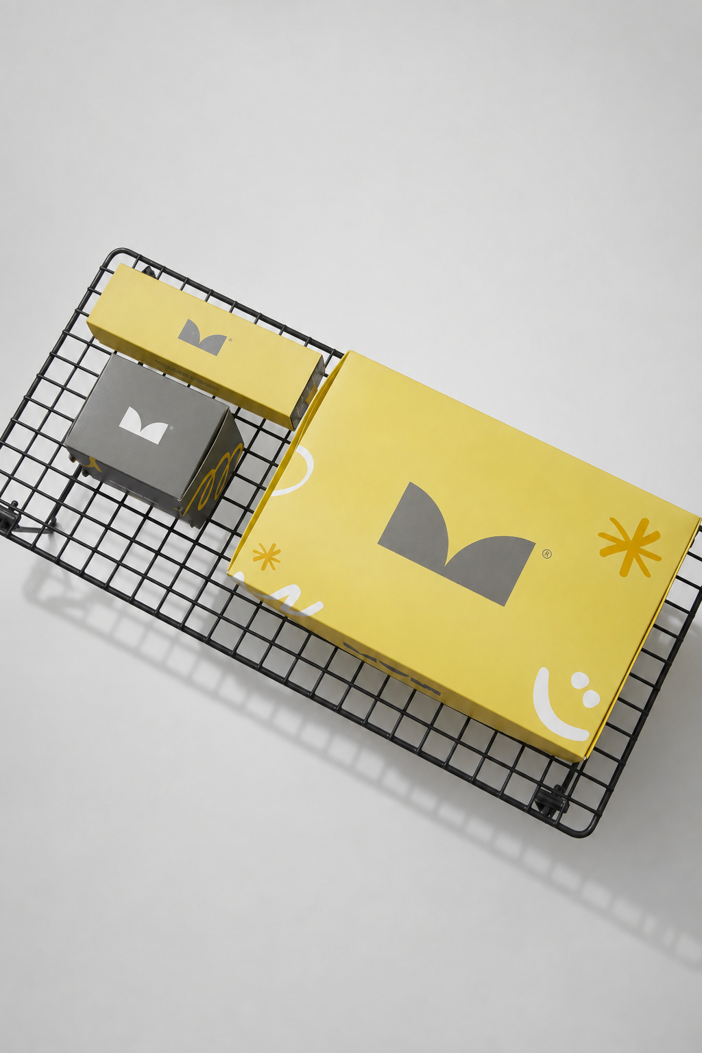 MUN's yellow and grey packaging system, arranged on a black metal structure.