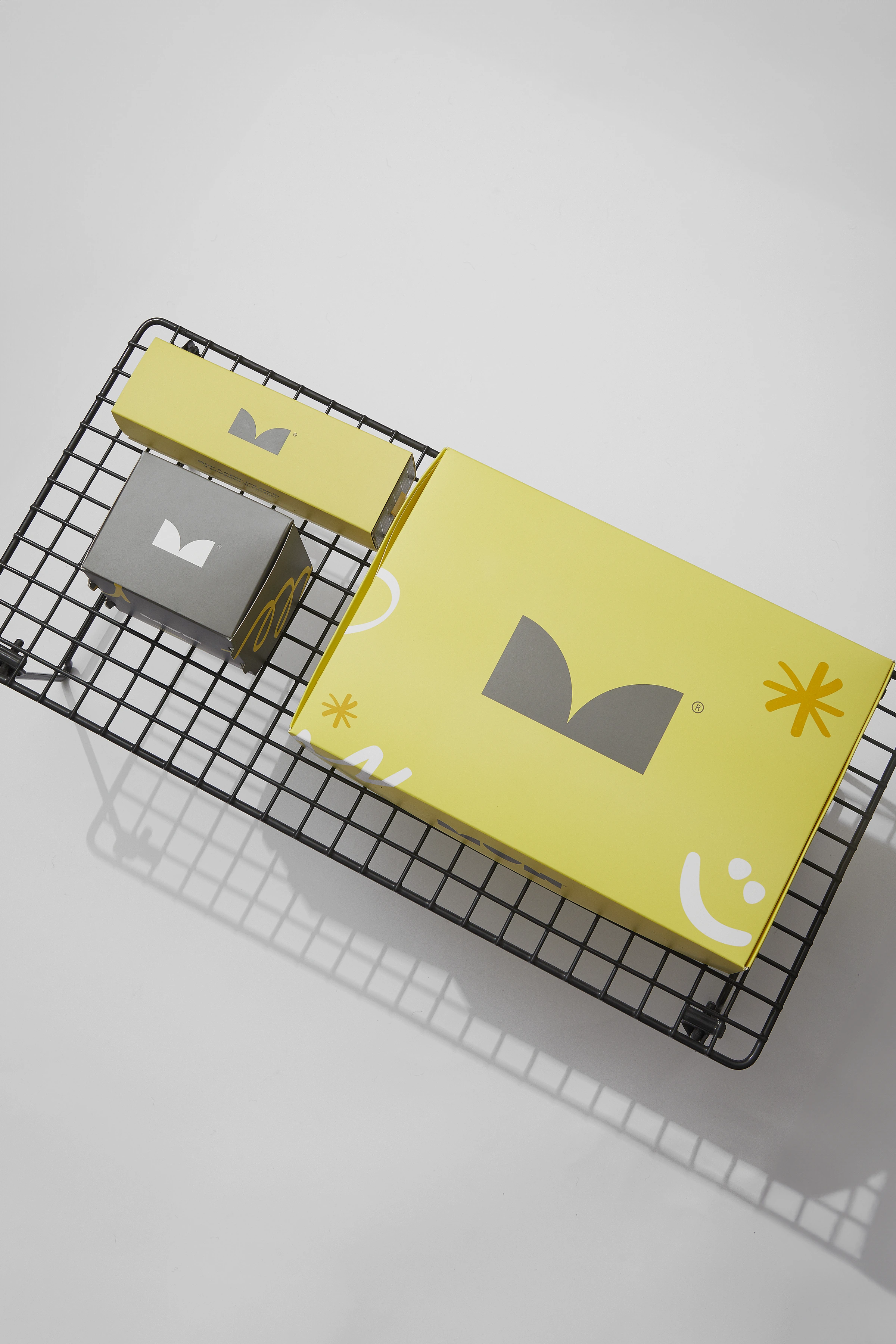 Sistema de packaging MUN en amarillo y gris, dispuesto sobre una estructura metálica negra.