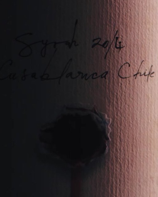 Escritura manuscrita sobre una etiqueta de vino, detalle de origen