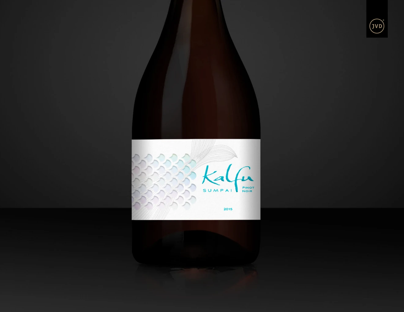 Botella Kalfu Sumpai con etiqueta blanca, escamas iridiscentes y logotipo turquesa.