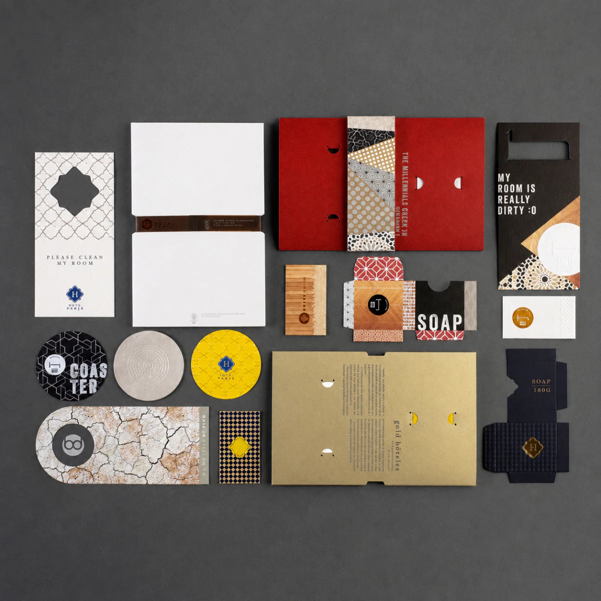 Flatlay del sistema completo Hotel Hache con colgador, tarjeta, posavasos y empaque de jabón.