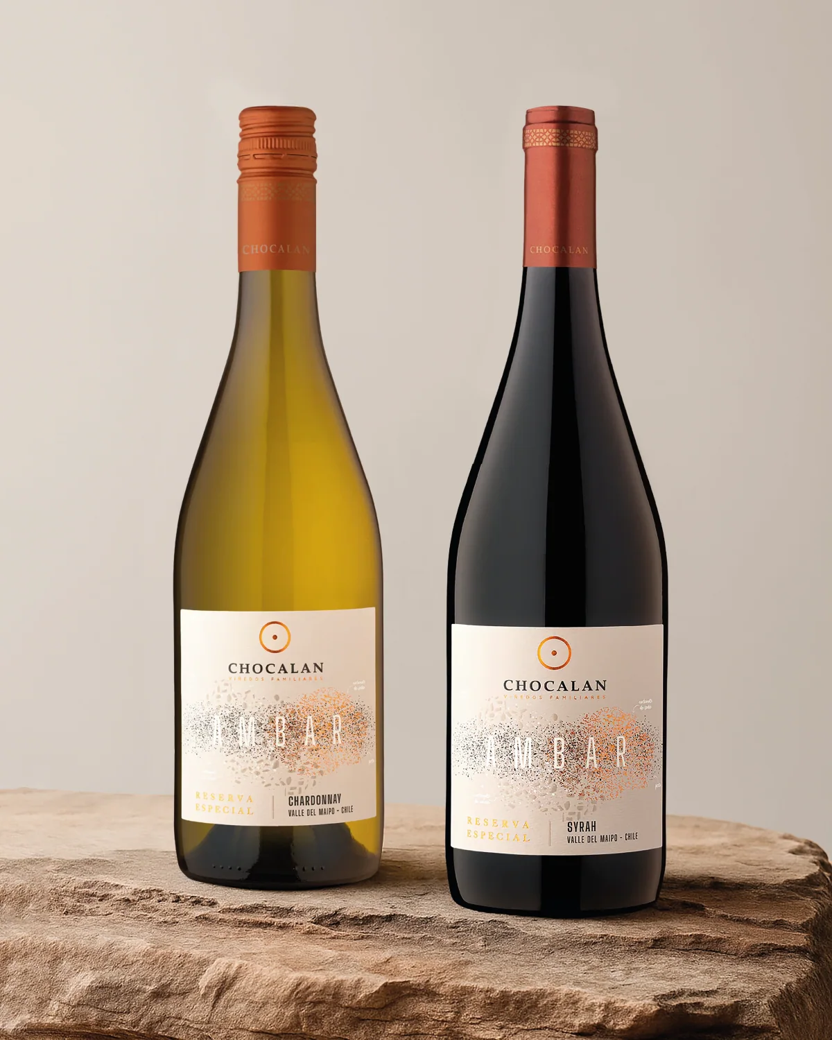 Botellas Ámbar blanca y tinta de Viña Chocalán sobre una base de piedra.