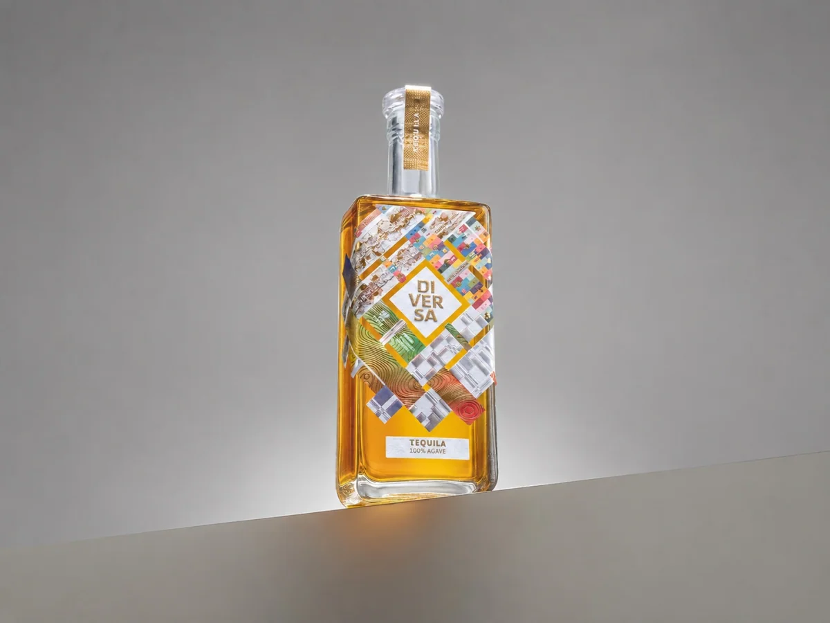 Botella DIVERSA Tequila con etiqueta de collage material construida por cinco estudios latinoamericanos, sobre fondo extendido
