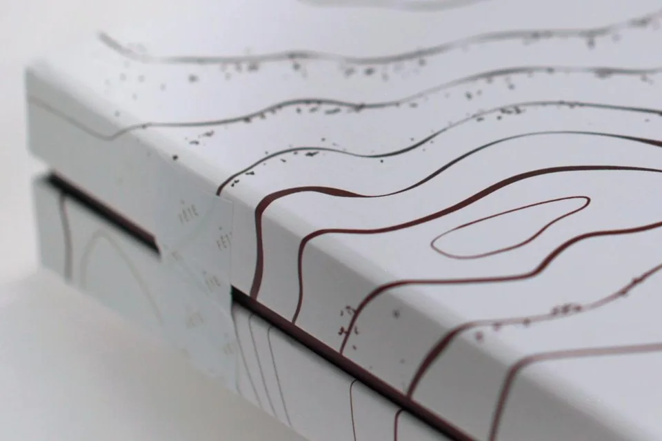 Estuche con relieve de líneas topográficas, detalle de acabado impreso