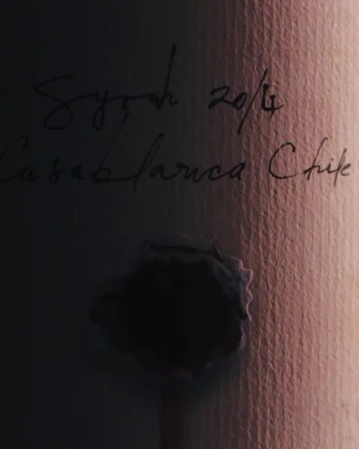 Escritura manuscrita sobre una etiqueta de vino, detalle de origen